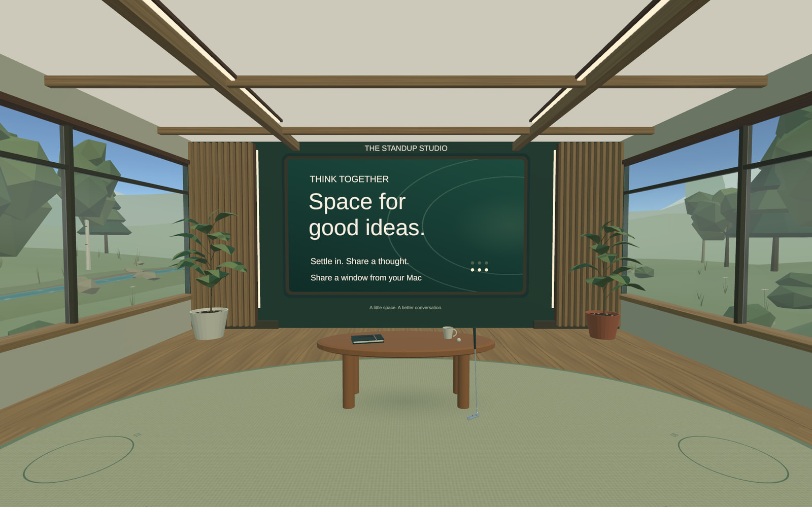 The current Unity studio: oak floor, a sage rug, wide landscape windows, plants, and a forest-green presentation wall.